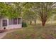 A beautiful backyard area with mature trees and a screened-in porch at 4715 Hill Rd, Powder Springs, GA 30127