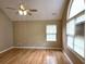 Bright bedroom with hardwood floors, ceiling fan, vaulted ceiling, and a large window at 102 Silver Summit Se Dr, Conyers, GA 30094