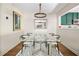 Modern dining room features a glass table, updated light fixture, and view into the kitchen at 1234 Weatherstone Ne Dr, Atlanta, GA 30324
