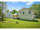 Wide shot of backyard featuring lush grass, an air conditioning unit, and the side of the house under a sunny sky at 1248 To Lani Ct, Stone Mountain, GA 30083