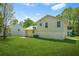 Wide shot of backyard featuring lush grass, an air conditioning unit, and the side of the house under a sunny sky at 1248 To Lani Ct, Stone Mountain, GA 30083