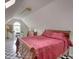 Attic with black and white checkered floors, bed with red bedspread, desk and accessories, and plenty of natural light at 1761 Mcdaniel Mill Rd Sw, Conyers, GA 30094