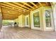 Spacious back porch featuring a wood floor, exposed beams, and an abundance of natural light at 1761 Mcdaniel Mill Rd Sw, Conyers, GA 30094
