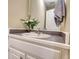 Close-up of bathroom sink with white cabinets, gray countertops, and decorative floral arrangement at 1761 Mcdaniel Mill Rd Sw, Conyers, GA 30094