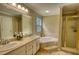 Bathroom with dual sinks, a soaking tub, and glass-enclosed shower at 1761 Mcdaniel Mill Rd Sw, Conyers, GA 30094