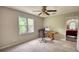 Bedroom with a view of trees from the window, desk, ceiling fan, and attached room with black and white floors at 1761 Mcdaniel Mill Rd Sw, Conyers, GA 30094