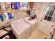 Practical laundry room featuring a washer, dryer, and convenient shelving at 1761 Mcdaniel Mill Rd Sw, Conyers, GA 30094