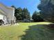 Large backyard with a patio, grill, trampoline, and mature trees perfect for outdoor enjoyment at 3049 Battlement, Loganville, GA 30052