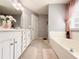 Bright bathroom featuring a soaking tub and white cabinets, complemented by neutral tile flooring at 3049 Battlement, Loganville, GA 30052