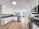 Bright kitchen with white cabinetry, stainless appliances, and hardwood floors offers a modern design at 3049 Battlement, Loganville, GA 30052