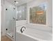 Bathroom featuring a large tub, separate glass shower, and window at 5086 Cumberland Ct, Villa Rica, GA 30180