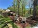 Tranquil backyard oasis features mature trees, lakeside views, and cozy seating for relaxation at 6255 Lakeview Dr, Buford, GA 30518