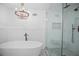 Luxurious bathroom with modern tub, glass-enclosed shower, and stylish lighting fixture at 6255 Lakeview Dr, Buford, GA 30518
