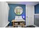 Stylish bathroom features a blue accent wall, round mirror, and modern vessel sink at 6255 Lakeview Dr, Buford, GA 30518