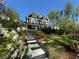 Beautiful two story lake house with a gray staircase and lush landscaping at 6255 Lakeview Dr, Buford, GA 30518