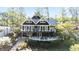 Charming lake house with a large deck, stone accents, and lush landscaping at 6255 Lakeview Dr, Buford, GA 30518