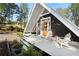 A-frame home with a charming front porch, cozy seating, and a welcoming orange door at 6255 Lakeview Dr, Buford, GA 30518