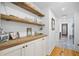 Hallway with wood floors, shiplap walls, built-in storage and view to a bathroom at 6255 Lakeview Dr, Buford, GA 30518