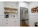 Charming kitchen with wooden shelves, white cabinetry, stainless steel refrigerator, and stylish countertop at 6255 Lakeview Dr, Buford, GA 30518