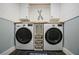 Well-organized laundry room with front load washer/dryer and custom storage shelves at 6255 Lakeview Dr, Buford, GA 30518