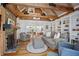 Cozy living room features wood floors, stone fireplace, exposed beams, and seamless flow at 6255 Lakeview Dr, Buford, GA 30518