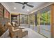 Inviting sunroom with wicker furniture, ceiling fan, and views of the surrounding landscape at 6255 Lakeview Dr, Buford, GA 30518