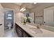 Bathroom featuring dual sinks, granite countertop, dark wood cabinets, and tile floor at 11210 Easthaven Pl, Duluth, GA 30097