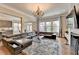 Bright living room features a large leather sectional, fireplace and a decorative chandelier at 11210 Easthaven Pl, Duluth, GA 30097