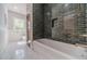 Stylish bathroom featuring green subway tile, a white soaking tub, and hexagon tile flooring at 181 W Hightower Trl, Social Circle, GA 30025
