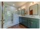 Stylish bathroom featuring a double vanity, marble counters, and a glass-enclosed shower at 181 W Hightower Trl, Social Circle, GA 30025