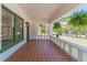 Inviting front porch with brick flooring, hanging plants, and classic railing, creating a cozy outdoor space at 181 W Hightower Trl, Social Circle, GA 30025