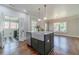 Chic kitchen island with a sink, seating, and views to a dining room with windows at 181 W Hightower Trl, Social Circle, GA 30025