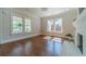 Sunlit living room with hardwood floors, a fireplace, and large windows at 181 W Hightower Trl, Social Circle, GA 30025