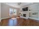 Elegant living room with hardwood floors, a white fireplace with shelving, and ample natural light at 181 W Hightower Trl, Social Circle, GA 30025