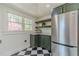 Cozy pantry with stainless steel refrigerator, green cabinetry, and black and white marble floor at 181 W Hightower Trl, Social Circle, GA 30025