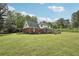 View of a large backyard featuring a home with a deck and green lawn at 2156 Fairway Cir, Duluth, GA 30096