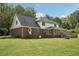 Expansive backyard featuring a well-maintained lawn, deck, and rear view of a brick home with a sunroom at 2156 Fairway Cir, Duluth, GA 30096