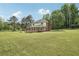 Large backyard with lush green grass, mature trees, and a view of the home's deck at 2156 Fairway Cir, Duluth, GA 30096