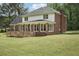 Backyard showcasing the deck, sunroom, brick exterior and expansive green lawn at 2156 Fairway Cir, Duluth, GA 30096
