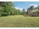 Expansive backyard featuring a large lawn, mature trees, and a deck area off the home at 2156 Fairway Cir, Duluth, GA 30096