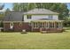 Backyard view with brick exterior, sunroom, deck, large lawn, and landscaping at 2156 Fairway Cir, Duluth, GA 30096