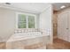 Bathroom showcasing a tiled soaking tub next to a walk-in shower and window, offering a spa-like experience at 2156 Fairway Cir, Duluth, GA 30096