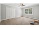 Spacious bedroom featuring carpet floors, a ceiling fan, and a window for natural light at 2156 Fairway Cir, Duluth, GA 30096