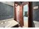 Bathroom with sink, wooden cabinets, floral wallpaper and a view into another room at 3141 Burnt Hickory Nw Rd, Marietta, GA 30064
