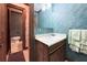 Bathroom with marble wallpaper, wood cabinet and sink, towels, and a view of the toilet at 3141 Burnt Hickory Nw Rd, Marietta, GA 30064
