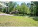 Two-story brick house with vibrant blue shutters on a large grassy lot surrounded by mature trees at 3141 Burnt Hickory Nw Rd, Marietta, GA 30064