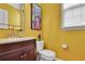 Powder room featuring yellow walls, a wood vanity, and a modern sink at 3870 Cabalzar St, Cumming, GA 30040