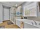 Bright bathroom featuring a soaking tub with a shower, and wood-look flooring at 3870 Cabalzar St, Cumming, GA 30040