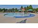 Community pool with splash features, pergolas, umbrellas, and ample seating around the perimeter at 3870 Cabalzar St, Cumming, GA 30040