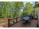 Outdoor deck with a grill and dining table overlooking a wooded backyard at 3870 Cabalzar St, Cumming, GA 30040
